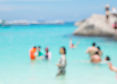 Blurry abstract background of tourist walking on beach and sea shore with mountain at sunny day,summer vacation conceptの写真素材