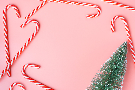 Top view of Christmas tree with many candy cane on pastel pink  background.Holiday festive celebration greeting card with copy space to addng textの写真素材