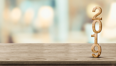 New year 2019 wood number (3d rendering) on wooden table at blur abstract bokeh light background,Mock up banner space for display or montage of product,holiday celebration greeting cardの写真素材