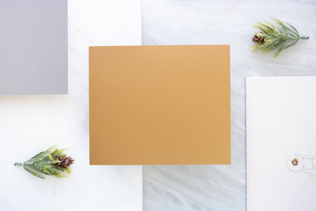 Top view of blank gold card overlap on envelop and grey card with pine leaf on two layer step of marble table top.Mock up template for display of design .luxury business itemsの写真素材