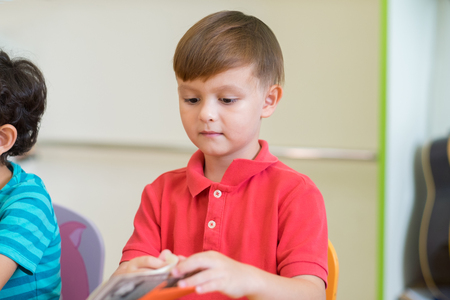 Caucasian boy ethnicity kid learning in classroom with friends and teacher  in kindergarten pre school, education conceptの写真素材