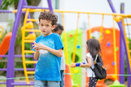 portrait of kids boy having fun at children's climbing toy with friend at school playground,back to school activity.kindergarten preschoolの写真素材