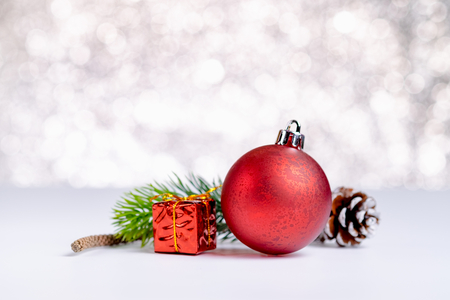 Close up group of red christmas glossy ball and gift box on white table at sparkling blue bokeh abstract blur background,Holiday seasonal greeting card,Leave space for adding textの写真素材