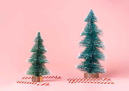 Christmas tree with candy cane on pastel pink studio background.Holiday festive celebration greeting card with copy space to addng textの写真素材