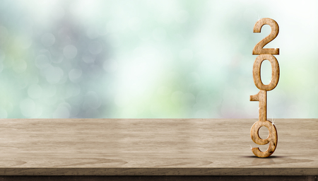 New year 2019 wood number (3d rendering) on wooden table at blur abstract green bokeh background,Mock up banner space for display or montage of product,holiday celebration greeting cardの写真素材