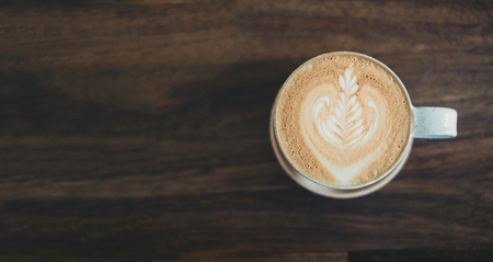 Top view of hot cappuccino coffee cup on wooden tray with latte art on wood table at cafe,Banner size food and drink concept.leave copy space for adding textの写真素材