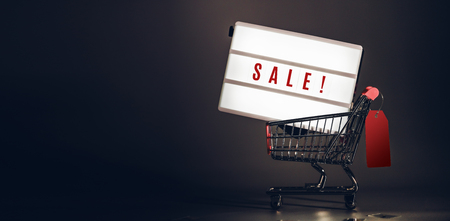 Sale light box in shopping cart with price tag at dark studio room banner size.Mock up header leave space for adding text or design for promote business campaign on lineの写真素材
