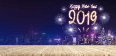 Happy new year 2019 fireworks over cityscape at night with empty wood plank table top,Banner mock up template for display or montage of product for holiday promotion advertisingの写真素材