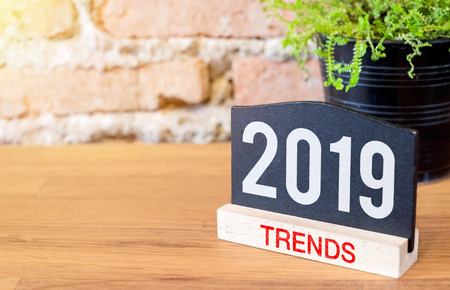 New year 2019 trends on blackboard sign and green plant on wood table at brick wall.Business plan for next yearの写真素材