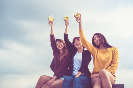 Happy group of asia girl friends enjoy laughing and cheerful toast sparkling wine glass at rooftop party,Holiday celebration festive,teeage lifestyle,freedom and funの写真素材