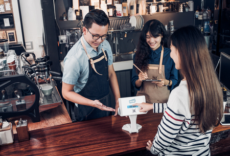 customer self service order drink menu with tablet screen and pay bill online at cafe counter bar,seller coffee shop accept payment by mobile.digital lifestyle conceptの写真素材
