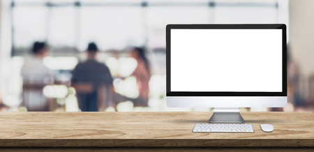 Blank screen desktop computer on wooden table top with blur people working at creative office bokeh background,Mock up for display or montage of designの写真素材