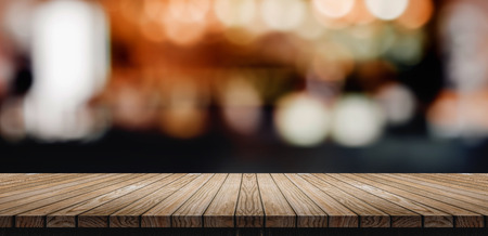 Plank Wood table top with blur nightclub bar counter with bokeh light background,banner mock up for display of product or design contentの写真素材