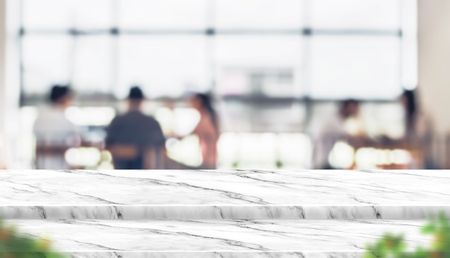 Empty step marble table top food stand with blur people in coffee shop background bokeh light and leaf foreground,Mock up for display or montage of product,Banner for advertise on online media,business presentationの写真素材