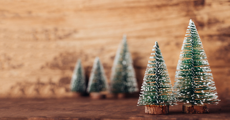 mini christmas tree wood on rustic wooden table and dark brown hardwood wall.winter holiday seasonal greeting card.leave space to adding text or designの写真素材