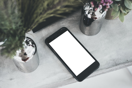 top view blank white screen mobile on concrete table with plant in vase.mock up for display of design or content.digital lifestyleの写真素材