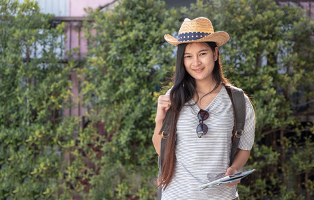 Asian woman traveler backpacker looking for route of place with map on street in when travel in city,journey tripの写真素材