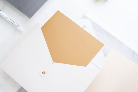 top perspective view of blank golden card in white envelop on two layer step of marble table top.Mock up template for display of design,modern business itemsの写真素材