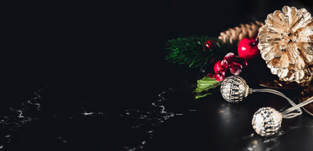 Glowing light string and pine cone and mistletoe decoration on marble table and blue background.Winter holiday greeting card.banner for display of design or contentの写真素材