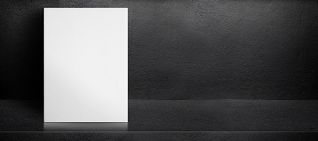 Blank white poster leaning at black interior cement room background,mock up banner template for display of design,leave side space for adding text for advertisingの写真素材