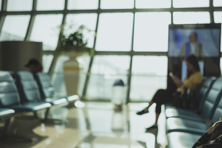 Blurred background,Traveler waitng for flight at Terminal Departure at airport with bokeh light,transportation conceptの写真素材