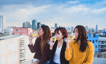 Happy group of asian girl friends enjoy laughing and cheerful sparkling wine glass at rooftop party,Holiday celebration festive,teeage lifestyle,freedom and funの写真素材