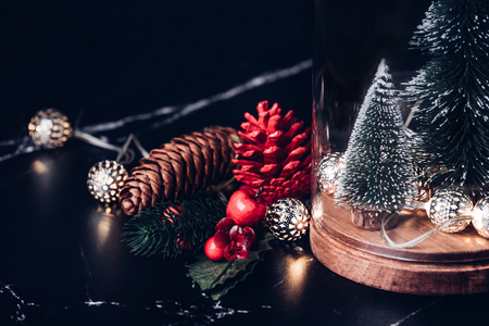 Christmas tree and glowing light string and pine cone and mistletoe decoration on marble table and blue background.Winter holiday greeting cardの写真素材