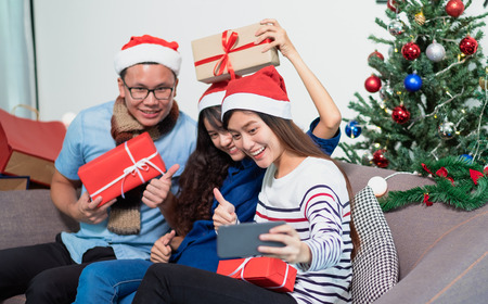 Christmas party with friends, asian woman selfie with smiling face with friends,Holiday celebration conceptの写真素材
