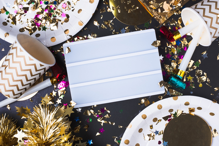 Empty light box with party cup,party blower,tinsel,confetti.Fun Celebrate New year holiday or birthday and anniversary party time table top view.mock up for adding text or designの写真素材