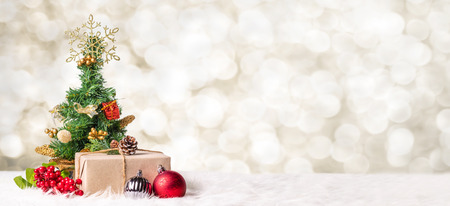 Christmas tree and gift box at blur bokeh light background,Winter holiday banner greeting cardの写真素材