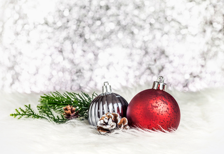 Christmas decoration ball on white fur at silver bokeh light background,Holiday greeting card.の写真素材