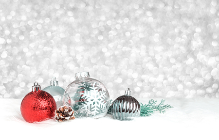 Christmas decoration ball on white fur at silver bokeh light background,Holiday greeting card.の写真素材