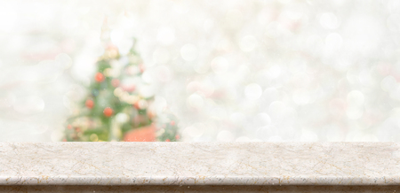 White marble table top at blur bokeh christmas tree decor with string light background when show falling,Winter holiday greeting cardの写真素材