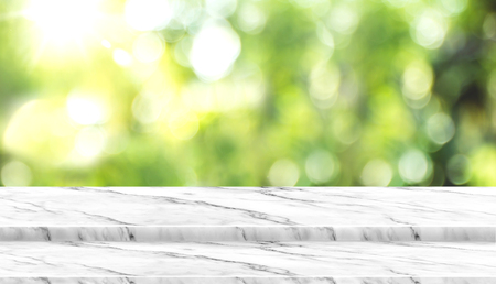 Empty white marble table top with blur tree in park with bokeh light at background,Mock up template for display of your design,Banner for advertise of product,panorama view.