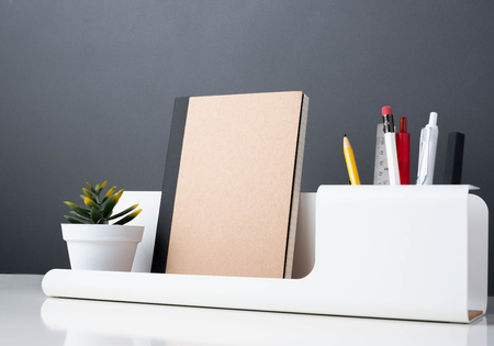 notebook on modern office stationery on white table.pencil, notepad,ruler,pen and pencil box with plant.Mock up paper note for display of design or contentの写真素材