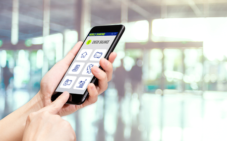 Hand holding mobile with mobile banking apps on smartphone screen at cafe restaurant,Digital lifestyle,modern financial business conceptの写真素材