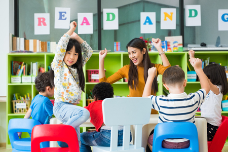 Happy Asian female teacher and mixed race kids in classroom,Kindergarten pre school conceptの写真素材