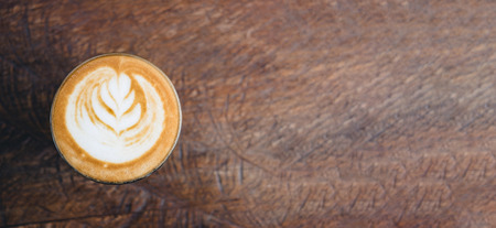 Top view of hot cappuccino coffee cup on wooden tray with latte art on wood table at cafe,Banner size food and drink concept.leave copy space for adding textの写真素材