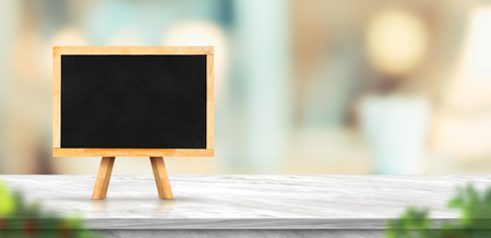Blackboard on white marble table and blurred soft light table in luxury restaurant with bokeh background. product display template.Business presentationの写真素材