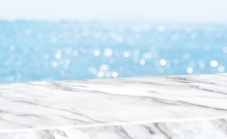 Empty glossy white marble table top with blur sky and sea boekh background,banner mock up template for display of productの写真素材