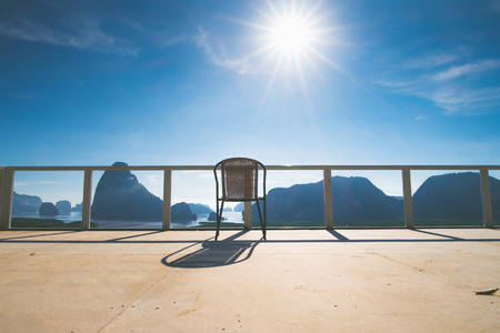 Chair on terrace at panoramic sea view with sun and blue sky.tropical climate view.の写真素材