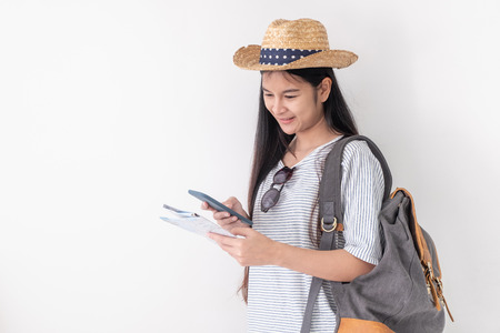 Asian woman traveler backpacker wear sunglasses use map to search for route location of place with gps on white background,Technology in lifestyleの写真素材
