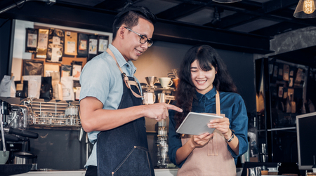 Asia Barista waiter take order from customer in coffee shop,cafe owner writing drink order at counter bar,Food and drink business concept,Service mind concept.restaurant workerの写真素材