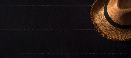 Top view of Summer brown panama straw hat on linen navy blue cloth.vacation travel concept.copy space for adding text.の写真素材