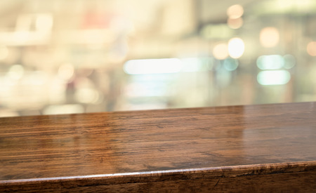 wood table at restaurant blur background.Empty perspective hardwood bar with blur coffee shop with bokeh light,Mock up for display or montage of product,Banner or header for advertise on online media.の写真素材