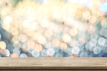 Empty brown wood table top with blur sparkling soft pastel blue and orange bokeh abstract background,panoramic banner for display or montage of product,Holiday seasonal concept backdrop.の写真素材