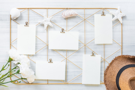 Top view set of note pad clip frame and summer hat with flower on white wood table.summer vacation backgroundの写真素材