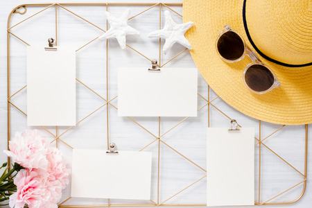 Top view set of note pad clip frame and summer hat with flower on white wood table.summer vacation backgroundの写真素材