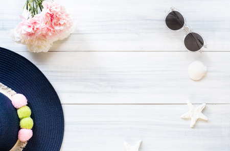top view of summer blue female hat with sunglasses and shell and star fish decoration on white wood table.summer vacationの写真素材