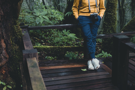 Close up backpacker low body take a rest in rain forest natural trail wood bridge.holiday adventure vacation.の写真素材
